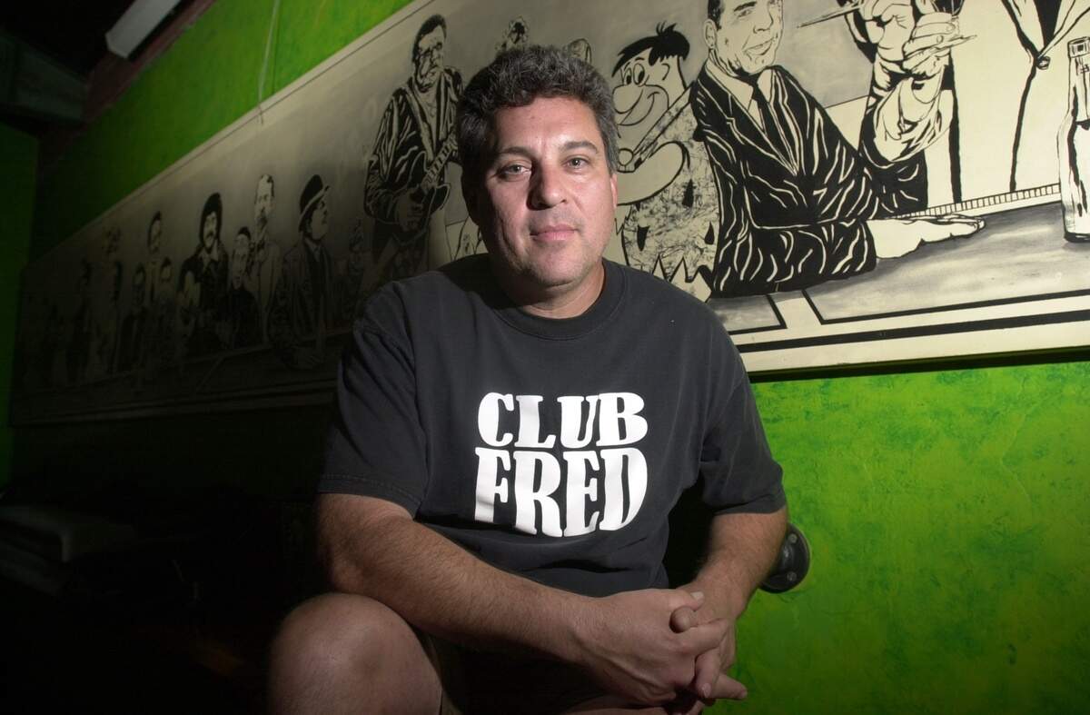 Fred Martinez, in a picture from Club Fred in 2000, sits in front of a mural of famous "Freds.” The 30-foot mural was recently re-installed inside Summer Fox Brewery.